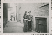 860784 Afbeelding van mevr. Paanakker met haar vriendin Ineke (rechts) in carnavalskledij in de Hogebergsteeg tussen ...